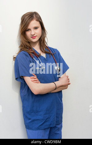 Ritratto di una donna chirurgo in piedi con le braccia incrociate su sfondo colorato Foto Stock