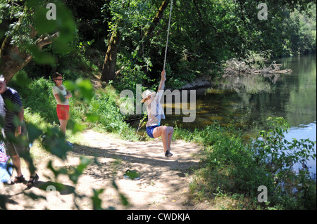 Famiglia avente divertimento su una fune dal fiume nel sacco regione del sud-ovest della Francia Europa Foto Stock