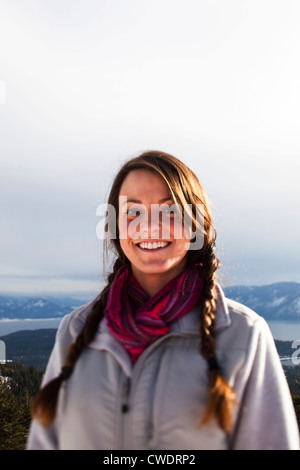 Una giovane e bella donna sorridente si arresta per un ritratto su una escursione invernale in Idaho. Foto Stock