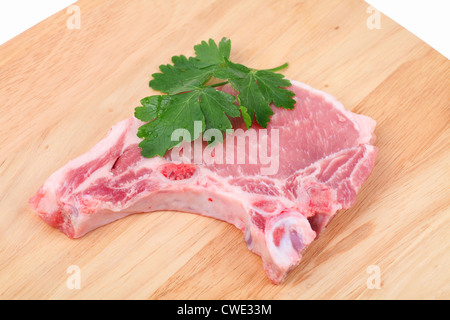 Tritare la carne di maiale e una foglia di prezzemolo su un tagliere. Foto Stock