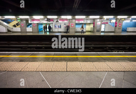 I passeggeri in attesa del loro treno all'Embankment Tube Station Foto Stock