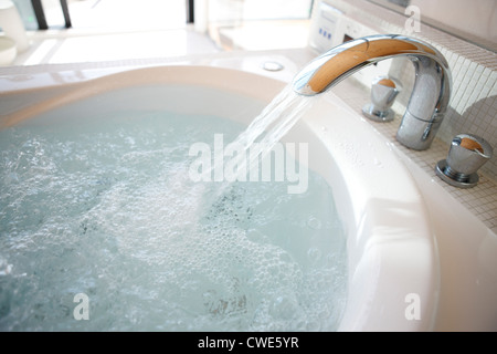 Versa acqua dal rubinetto nel lavello Foto Stock