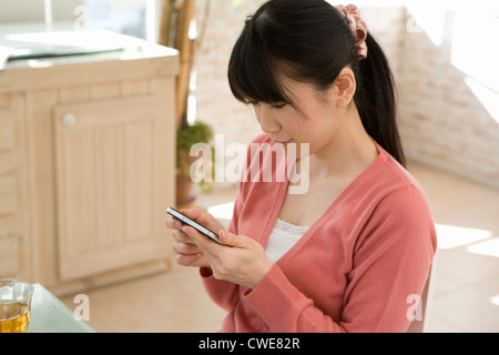 Giovane donna utilizza lo smartphone Foto Stock