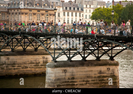 I viaggiatori giovani riuniti sul Pont des Arts di Parigi Francia alla sera Foto Stock