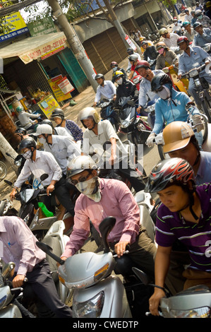 Vista orizzontale del caotico traffico delle ore di punta del traffico con centinaia di ciclomotori e i loro passeggeri pillion home guida. Foto Stock