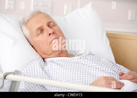 Senior uomo addormentato nel letto di ospedale Foto Stock