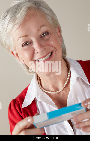 Senior donna tenendo prescrizione dei farmaci pack Foto Stock