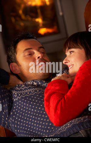 Coppia di mezza età in chat sul divano da caminetto Foto Stock