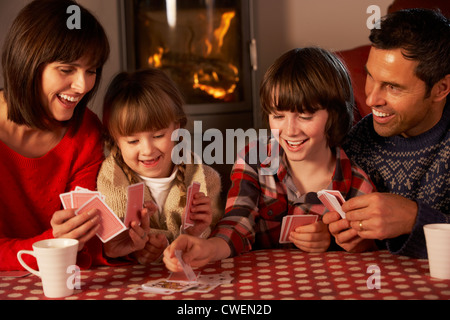 Ritratto di famiglia giocando a carte da caminetto Foto Stock