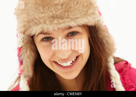 Ritratto di ragazza adolescente nella neve indossando cappello di pelliccia Foto Stock