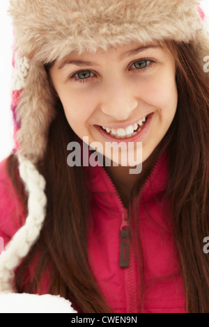 Ragazza adolescente tenendo palla di neve indossando cappello di pelliccia Foto Stock