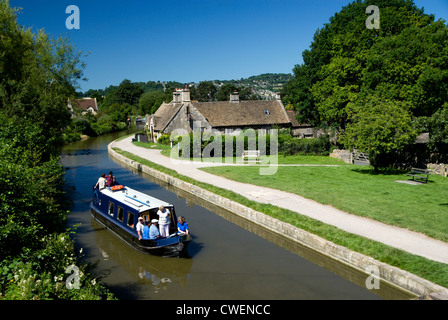 Strette in barca a vela passato il George Inn on the Kennet and Avon Canal, Bathampton Near Bath, Somerset, Inghilterra. Foto Stock