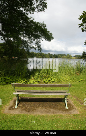 Un vuoto di una panchina nel parco che si affacciava su una vista sul lago a Ellesmere Shropshire Foto Stock