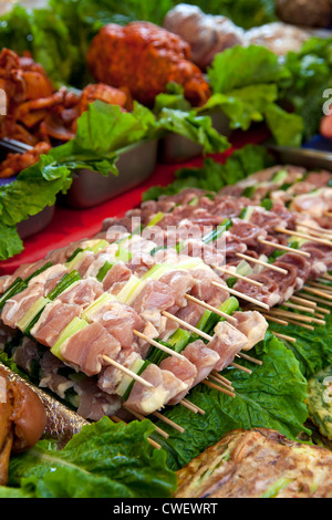 Pile di carne cruda e spiedini di pollo in attesa di essere cucinato. Foto Stock