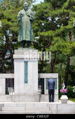 Un anziano uomo coreana rende omaggio al parco Topkol a Seul, in Corea. Foto Stock