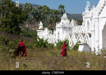Myanmar Birmania. Mingun, vicino a Mandalay. Due giovane debuttante i monaci buddisti di lasciare il Hsinbyume Paya, uno stupa costruito nel 1816. Foto Stock