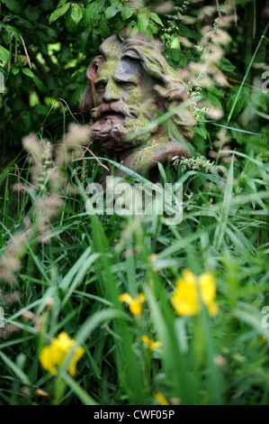 Una statua nascosta da sottobosco in un giardino England Regno Unito Foto Stock