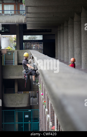 Una calandra esegue riparazioni di edifici presso la Barbican Estate di Londra, Regno Unito, evidenziando lavori di manutenzione specialistici sull'iconica architettura brutalista all'interno di uno storico complesso residenziale nella City di Londra Foto Stock