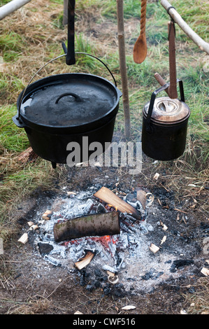 Campfire con ghisa di pentole e tegami appeso su un fuoco di legno Foto Stock