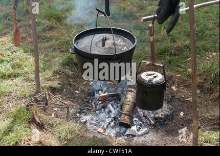 Campfire con ghisa di pentole e tegami appeso su un fuoco di legno Foto Stock