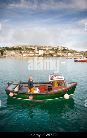 Pescatore in uscita o di ritorno al porto di una piccola barca da pesca di St ives Cornwall Regno Unito Foto Stock