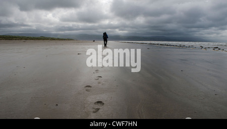 Escursionista solitario passeggiate lungo la spiaggia Foto Stock