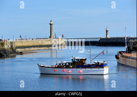 La barca lascia il porto di Whitby North Yorkshire England Regno Unito Foto Stock