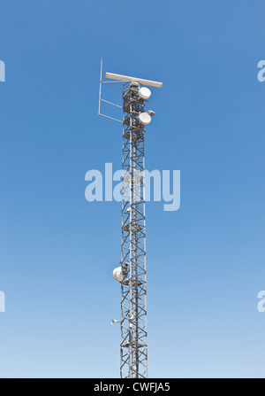 Torre di comunicazione contro un cielo blu chiaro Foto Stock