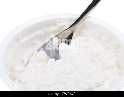 Cucchiaio di metallo in vasca del cottage cheese isolati su sfondo bianco Foto Stock