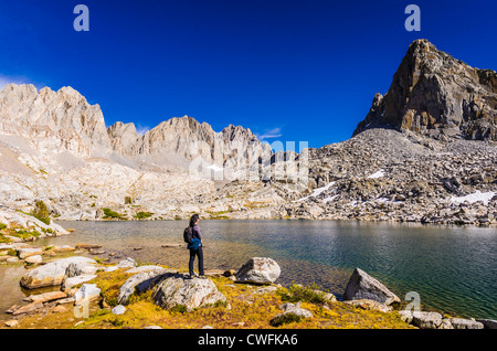 Escursionista sotto il picco isoscele e Palisades nel bacino Dusy, Kings Canyon National Park, California USA Foto Stock