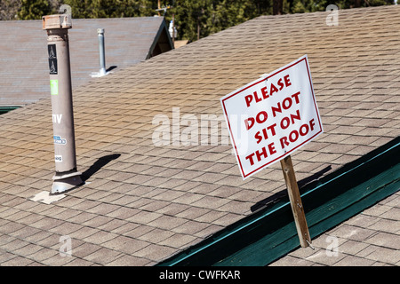 'Non sedersi sul tetto' segno sulla costruzione sul fondo delle piste da sci a Big Bear Mountain in Calfornia, STATI UNITI D'AMERICA Foto Stock