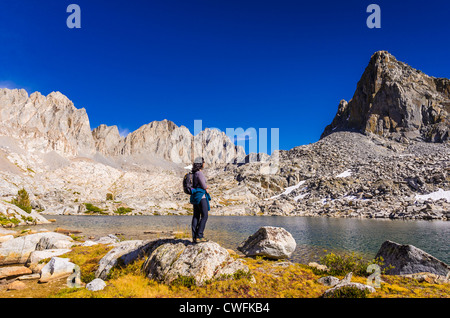 Escursionista sotto il picco isoscele e Palisades nel bacino Dusy, Kings Canyon National Park, California USA Foto Stock