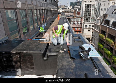 Coperture gli appaltatori che lavorano su un tetto nella città di Londra. Foto Stock