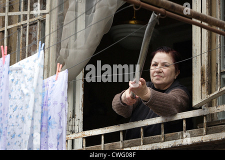 Una donna anziana pende lavanderia su Foto Stock