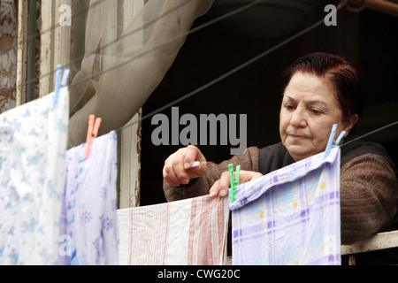 Una donna anziana pende lavanderia su Foto Stock