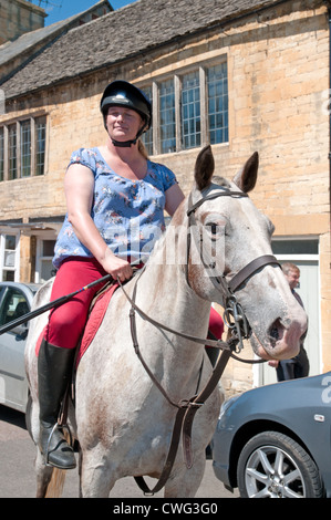 Signora cavallo Cavaliere a basso High Street in Chipping Campden Gloucestershire in Inghilterra Foto Stock