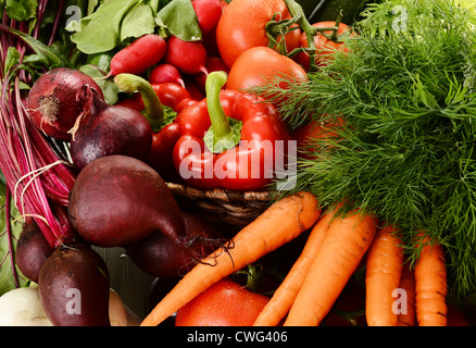 Composizione con verdure crude e cesto di vimini Foto Stock