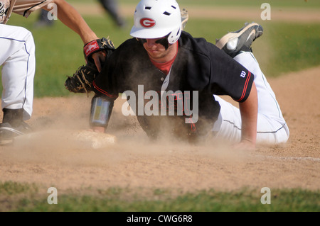 Base di baseball testa runner prima immersione torna alla prima base per battere il tag del primo baseman. Foto Stock