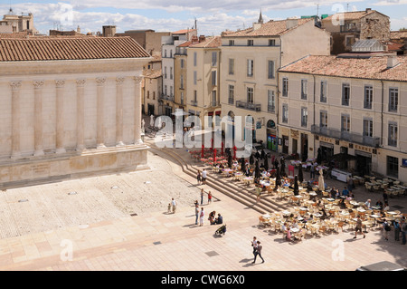 Pavement Cafe Carree con al fresco e tabelle vicino al Maison Carree tempio romano a Nimes Francia Foto Stock