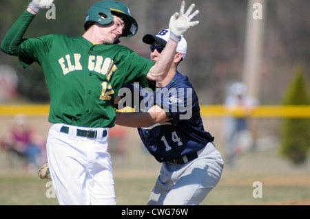 Il baseball primo baseman tag di un hitter prima che egli possa raggiungere la prima base durante una scuola di gioco. Foto Stock