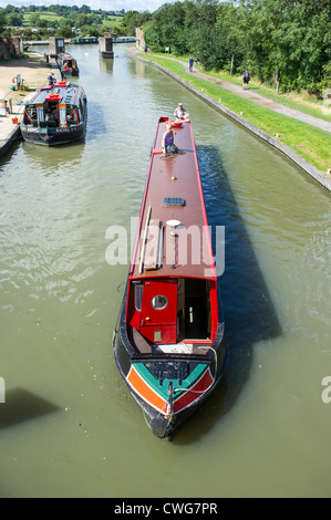 Guardando verso il basso su una piccola barca che sta per passare sotto un ponte Foto Stock