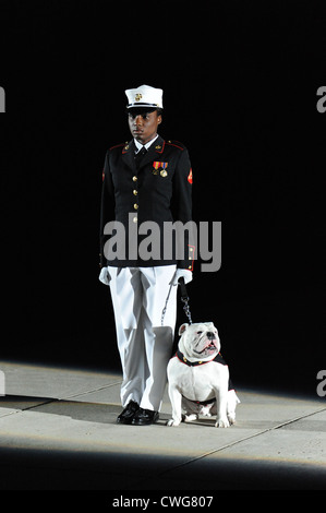 Un marine statunitense gestore mascotte sorge al centro a piedi con la Caserma marini Washington mascotte Cpl. Chesty XIII durante la sfilata serale Luglio 10, 2010 a Washington D.C. Una sfilata è tenuto presso la caserma ogni venerdì durante i mesi estivi. Foto Stock