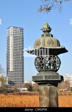 Shinobazu stagno nel Parco di Ueno e dello skyline di Tokyo al tramonto Foto Stock