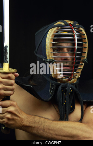 Fighter con lama katana di Kendo e casco su sfondo nero Foto Stock