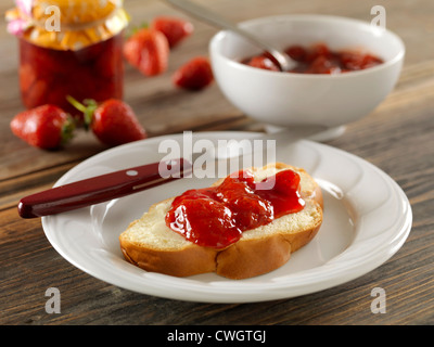 Gelatina di fragole con scone su piastra bianca Foto Stock