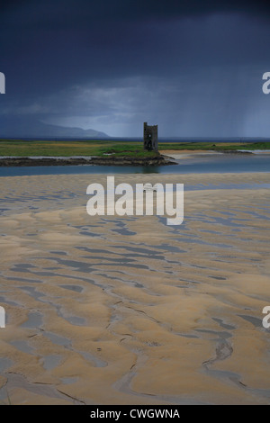 Torre di avvistamento irlandese sulla spiaggia di Tralee con cielo tempestoso, ondulazioni sabbiose e pied wagtail in primo piano. Foto Stock