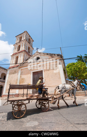 Uomo cubano in sella ad un cavallo e buggy davanti la Iglesia del Buen Viaje chiesa cattolica, Remedios, Cuba. Foto Stock