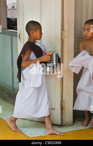 I monaci buddisti sono alimentati ogni giorno alle 11.00 presso il monastero MAHAGANDAYON - Mandalay, MYANMAR Foto Stock