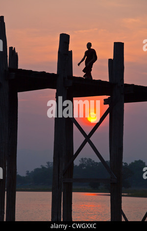 Il birmano utilizzare il teak U BEINS ponte per commutare tra il Lago Taungthaman presso sunrise - AMARAPURA, MYANMAR Foto Stock