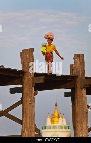 Il birmano utilizzare il teak U BEINS ponte per commutare tra il Lago Taungthaman presso sunrise - AMARAPURA, MYANMAR Foto Stock